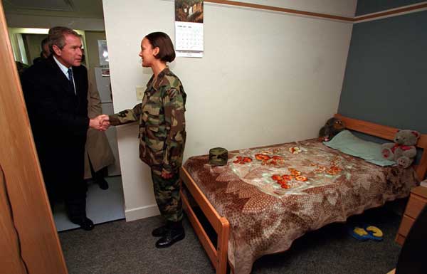 President George W. Bush visits a soldier in her barracks at Ft. Stewart, Georgia on February 12, 2001