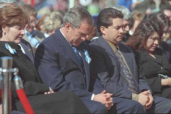 President George W. Bush and Laura Bush bow their heads in prayer at the dedication ceremony for the Oklahoma City National Memorial February 19, 2001.