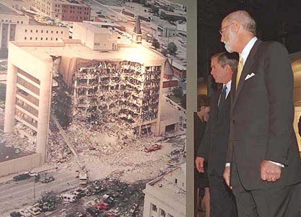 President George W. Bush looks at a photo of the Oklahoma City Murrah Federal Building bombing at the Oklahoma City National Memorial February 19, 2001.