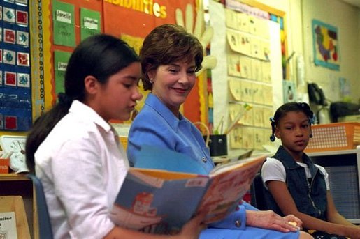 Laura Bush listens as a student at Caesar Chavez Elementary School reads during a “Ready to Read Ready to Learn” visit to the school in Hyattsville, Maryland, Feb., 26, 2001. White House photo by Carol T. Powers.