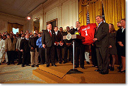The Univerity of Oklahoma football team presents President George W. Bush with a jersey in the East Room of the White House on March 5, 2000. (WHITE HOUSE PHOTO BY ERIC DRAPER)