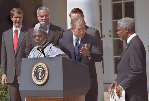 President George W. Bush welcomes UN Secretary General Kofi Annan to the podium after his announcement of Presidential HIV/AIDS Trust Fund Initiative as Nigerian President Olusegun Obsanjo looks on at left in the Rose Garden, Friday, May 11, 2001. White House photo by Eric Draper.