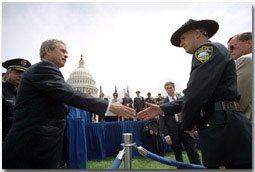 President George W. Bush greets a police officer from Flagstaff, AZ., after placing a wreath to commemorate the 20th Annual Peace Officers Memorial Service at the Capitol.
