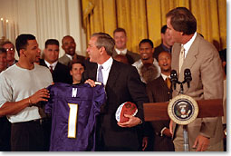 President George W. Bush accepts a jersey and football from the NFL Champion Baltimore Ravens on Thursday, June 8 at the White House.