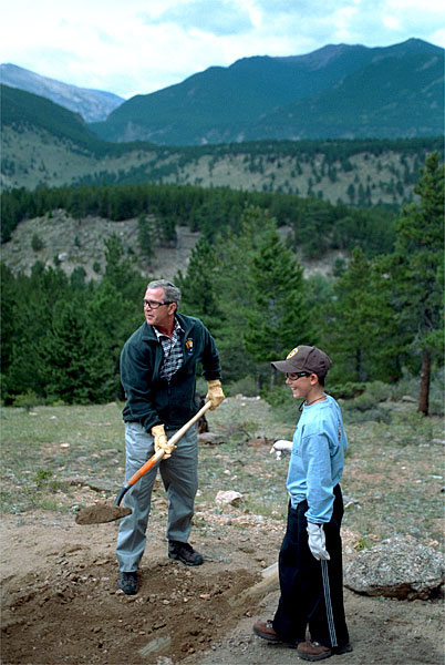 Working for his share of the picnic bounty, President Bush helps build a trail at Rocky Mountain National Park in Estes, Colo., Aug. 14. After sharing lunch with YMCA volunteers, the President addressed the media. 