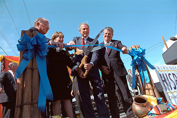 With help from officials from Albuquerque's Hispano Chamber of Commerce, President Bush cuts the ribbon to open the Barelas Job Oppurtinity Center Aug 15. White House photo by Moreen Ishikawa.