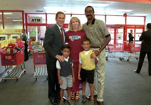After talking with several families about how far $600 can go during family shopping trips, President Bush poses for pictures with one of the families just outside the Target Snack Bar at a retail location in Kansas City, Mo., Aug. 21, 2001. White House photo by Moreen Ishikawa.