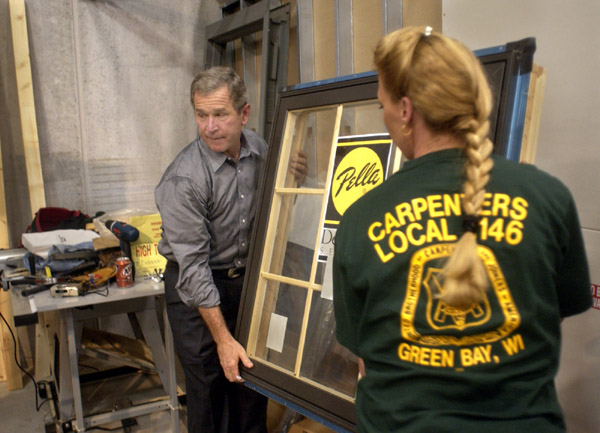 President George W. Bush assists a Union worker with the installation of a glass window frame during his tour of the Northern Wisconsin Regional Council of Carpenters Training Center in Kaukauna, WI., Monday, Sept. 3, 2001. WHITE HOUSE PHOTO BY ERIC DRAPER.