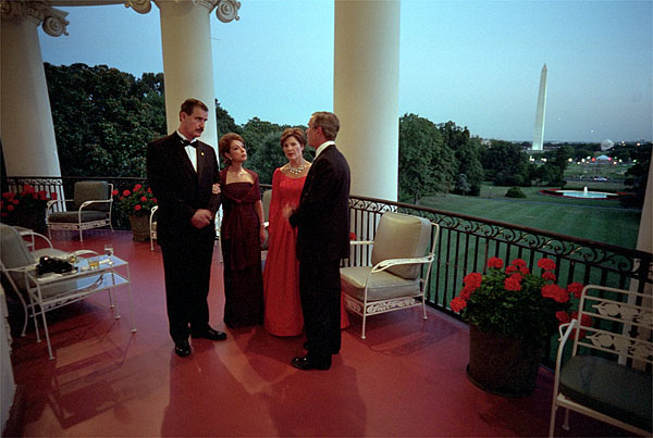 Mexican President Vicente Fox and his wife Martha Sahagun de Fox talk privately with President Bush and First Lady Laura Bush on the Truman Balcony of the White House before greeting guests at the state dinner Wednesday evening. After the dinner, the two couples and their friends watched fireworks from the balcony. White House photo by Eric Draper.