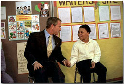 President George W. Bush talks with a student at Thurgood Marshall Extended Elementary School, where he announced his initiative, Friendship Through Education, Oct. 25. "We're going to ask schools all across the country to join with schools in other countries to spread the message that we care for each other, that we want to understand each other better," explained the President. White House photo by Eric Draper.