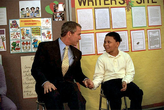 President George W. Bush talks with a student at Thurgood Marshall Extended Elementary School, where he announced his initiative, Friendship Through Education, Oct. 25. "We're going to ask schools all across the country to join with schools in other countries to spread the message that we care for each other, that we want to understand each other better," explained the President. White House photo by Eric Draper.