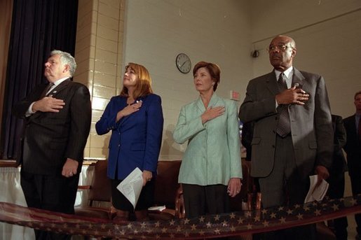 Laura Bush listens to the National Anthem with Bill and Elayne Bennett, left, and Secretary of Education Rod Paige, right, during a Best Friends for Our Children Event at Bertie Backus Middle School Nov. 7, 2001 in Washington, D.C. White House photo by Susan Sterner.
