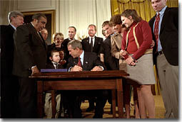 President George W. Bush looks over to Thomas Martello, 6, during the signing ceremony of the Victims of Terrorism Tax Relief Act in the East Room Jan. 23. "We're joined today by families who have lost loved ones in the great acts of evil," said the President. "As you draw on faith and personal strength to cope with your grief, I hope you'll also find comfort in the knowledge that your nation stands with you and prays for you. We mourn those whom we've lost, and we face the future together." White House photo by Eric Draper.