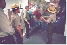 President George W. Bush looks over a topography map with national park service officer upon arriving at the Royal Palm Visitors Center at Everglades National Park, Fla., File photo. White House photo by Moreen Ishikawa.