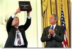 Steve Versace holds up the Medal of Honor that President George W. Bush presented to him on the behalf of his brother, Army Captain Humbert 