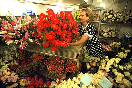 White House Florist Wendy Elsasser prepares an arrangement of red Gerbera Daises as one of the many bouquests to be used at the State Dinner for Polish President Alexander Kwasniewski tonight, July 17. White House photo by Tina Hager.