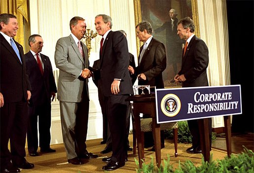 President George W. Bush shakes hands with Congressman Mike Oxley, R-OH, during the signing of the ceremony of the Sarbanes-Oxley Act in the East Room, July 30. "This new law sends very clear messages that all concerned must heed. This law says to every dishonest corporate leader: you will be exposed and punished; the era of low standards and false profits is over; no boardroom in America is above or beyond the law," said the President in his remarks. 