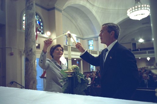 President George W. Bush and First Lady Laura Bush light a candle at St. John Episcopal Church in Washington, D.C., during a private service of prayer and remembrance Wednesday morning, September 11, 2002. White House photo by Eric Draper.