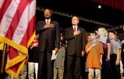 President George W. Bush pledges allegiance to the flag with Secretary of Education Rod Paige at a Pledge Across America event at East Literate Magnet School in Nashville, Tennessee on Tuesday, Sept. 17, 2002. 