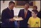 President George W. Bush and Matthew Skowronski, 13, a leukemia survivor, (right), admire the cake Lance Armstrong was given by the White House in honor of his 31st birthday. Armstrong, a cancer survivor and 4-time winner of the Tour De France, spoke Wednesday, Sept. 18, to encourage and support new cancer survivorship initiatives and legislation. White House photo by Paul Morse.