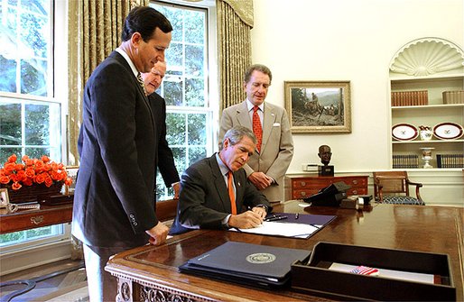 President George W. Bush signs The Flight 93 National Memorial Act in the Oval Office Tuesday, Sept. 24. The bill authorizes the building of a national memorial to the passengers and crew who died aboard Flight 93 when it crashed into Shanksville, Pa., during the Sept. 11 terrorist attacks. Standing with the President are Pennsylvania Congressman Sen. Rick Santorum, far left; Rep. John Murtha, center; and Sen. Arlen Specter. White House photo by Tina Hager.
