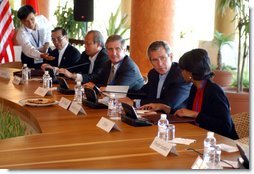 President George W. Bush speaks with National Security Advisor Condoleezza Rice at the start of the group meeting with ASEAN leaders 10th APEC leaders meeting in Los Cabos, Mexico, Saturday, Oct. 26, 2002. Also pictured seated from left are His Majesty Sultan Haji Hassanal Bolkiah Mu'Izzaddin Waddaulah and Pehin Dato Lim Jock Seng both of Brunei and Chief of Staff Andy Card. White House photo by Tina Hager.