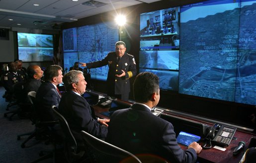 President George W. Bush along with Homeland Security Advisor Tom Ridge, left, and District of Columbia Mayor Anthony Williams, far left, listen to Police Chief Charles Ramsey explain the District's Metropolitan Police Department Synchronized Operations Center Tuesday, Nov. 12. White House photo by Paul Morse