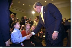 President George W. Bush talks to Solveig Haugen, her twin sister Liv and their younger brother Tad, after the signing of the Dot Kids Implementation and Efficiency Act of 2002 in the Roosevelt Room, Dec 4. The Haugen family of Loudoun County, Virginia is one family that will benefit from the act. The bill creates a second level Internet domain (kids.us), within the United States country code, that will provide a safe online environment for children ages 13 and under.  White House photo by Eric Draper