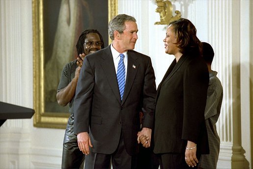 President George W. Bush congratulates Pamela Hedrick during a ceremony honoring graduates of welfare-to-work programs in the East Room. Ms. Hedrick was on public assistance for eight years in Columbus, Ohio, before volunteering at the Greenbriar Enrichment Center, where she organized a women's support group and received job training. The President’s Council of Economic Advisers (CEA) estimates the Jobs and Growth plan will create 1.4 million new jobs by the end of 2004. White House photo by Tina Hager.
