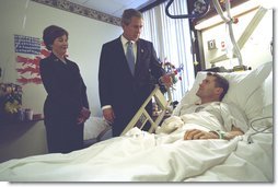 President George W. Bush and First Lady Laura Bush visit with Army Staff Sergeant Michael McNaughton, of Denham Springs, Louisiana, at Walter Reed Army Medical Center in Washington, D.C., Friday, January 17, 2003. Sergeant McNaughton was wounded on January 9 in Afghanistan. The First Couple visited four other wounded soldiers at the hospital.  White House photo by Eric Draper