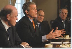 As Treasury Secretary John Snow, left, Director of National Economic Council Stephen Friedman, center, and Commerce Secretary Don Evans sit by his side, President George W. Bush takes a few questions from the media during a meeting with the National Economic Council in the Cabinet Room Tuesday, Feb. 25, 2003.  White House photo by Eric Draper