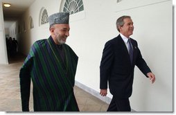 President George W. Bush and President Hamid Karzai of Afghanistan walk through the colonnade after meeting in the Oval Office Thursday, Feb. 27, 2003. White House photo by Tina Hager.