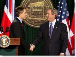 President George W. Bush and British Prime Minister Tony Blair shake hands after they conclude a joint news conference at the Camp David, March 27, 2003. "The United States and United Kingdom are acting together in a noble purpose. We're working together to make the world more peaceful; we're working together to make our respective nations and all the free nations of the world more secure; and we're working to free the Iraqi people," President Bush said.  White House photo by Paul Morse