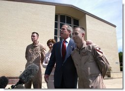 President George W. Bush puts his arm around Chief Warrant Officer David S. Williams as he speaks to the media with Chief Warrant Officer Ronald D. Young Jr., left, and Mrs. Bush after attending Easter church services at the 4th Infantry Division Memorial Chapel at Fort Hood, Sunday, April 20, 2003. Williams and Young are former POW's.  White House photo by Eric Draper