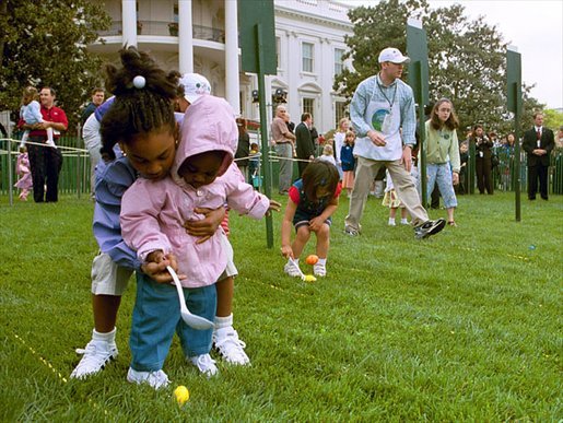 A helping hand is given during the Easter egg roll where little competitors use a spoon to carry a hard-boiled egg through the South Lawn race course and across the finish line at the White House Easter Egg Roll Monday, April 21, 2003. White House photo by Susan Sterner