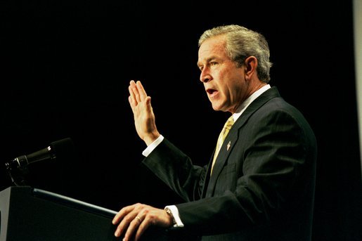 Recalling the experience of watching a Mexican-born Marine take America's oath of citizenship, President George W. Bush raises his right hand as he addresses the National Hispanic Prayer Breakfast in Washington, D.C., Thursday, May 15, 2003. White House photo by Eric Draper