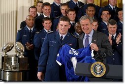 President George W. Bush receives a jersey during the presentation of the Commander-in-Chief's Trophy in the East Room Friday, May 16, 2003. "I'm proud to welcome back to the White House the Air Force Academy Falcons, who have now won the Commander-in-Chief's Trophy for their six consecutive year, and 16th time overall," said the President in his remarks.  White House photo by Paul Morse