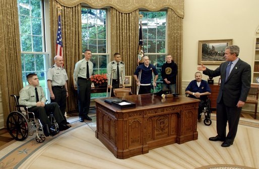 President George W. Bush talks with soldiers after taping his weekly radio address in the Oval Office Friday, May 16, 2003. Honoring Armed Forces Day on May 17th, the President invited soldiers to attend the recording of the address. White House photo by Eric Draper