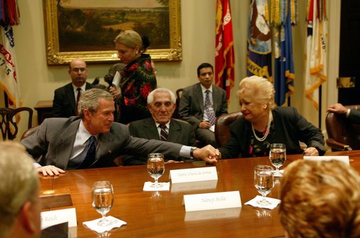 President George W. Bush reaches out to comfort Isabel Roque during a roundtable discussion with Cuban dissidents in the Roosevelt Room at the White House Tuesday, May 20, 2003. Ms. Roque spoke of family members currently imprisoned in Cuba. White House photo by Susan Sterner.