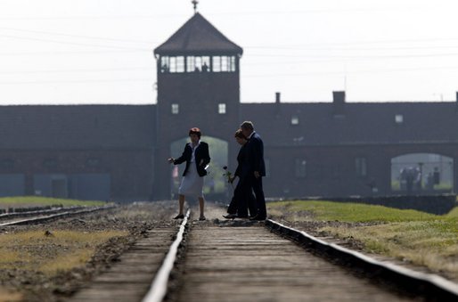 President Bush and Mrs. Bush are escorted across railroad tracks during a tour of the Birkenau concentration camp in Poland by Auschwitz Museum Senior Curator Dr. Teresa Swiebocka, Saturday, May 31, 2003. White House photo by Paul Morse