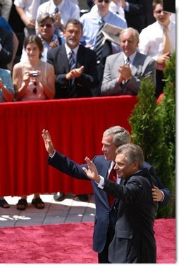 President George W. Bush and President of Poland Aleksander Kwasniewski acknowledge the audience following their speeches in the court yard of the Wawel Royal Palace in Krawkow, Poland, Saturday, May 31, 2003.  White House photo by Paul Morse