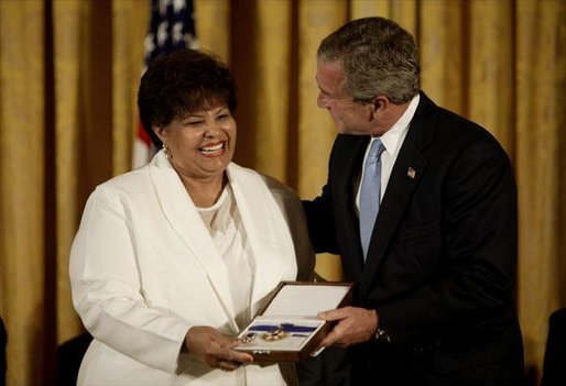 Vera Clemente accepts the Presidential Medal of Freedom from President George W. Bush on behalf of her husband Roberto Clemente Walker during a ceremony in the East Room Wednesday, July 23, 2003. A Hall of Fame baseball player, Mr. Clemente was committed to helping the less fortunate. The medal is the highest civilian award. White House photo by Paul Morse