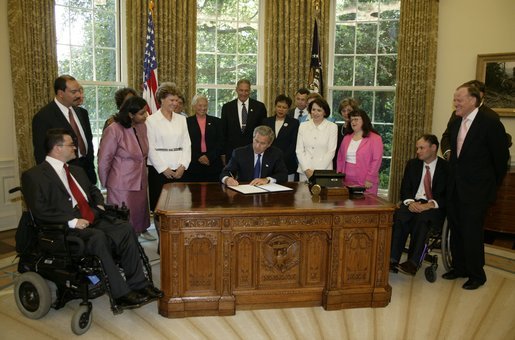 In honor of the 13th anniversary (July 26, 2003) of the Americans with Disabilities Act, President George W. Bush signs the executive order renaming the President's Committee on Mental Retardation to the President's Committee for People with Intellectual Disabilities (PCPID) in the Oval Office Friday, July 25, 2003. In addition to witnessing the signing, the PCPID were on hand to hear President Bush record his weekly radio address. White House photo by Paul Morse.
