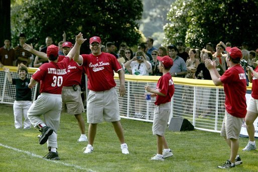 Coaches cheer their fellow teammate after he hit a home-run ball out of the park during a game in the White House South Lawn Tee-Ball League Sunday, July 27, 2003. White House photo by Lynden Steele.