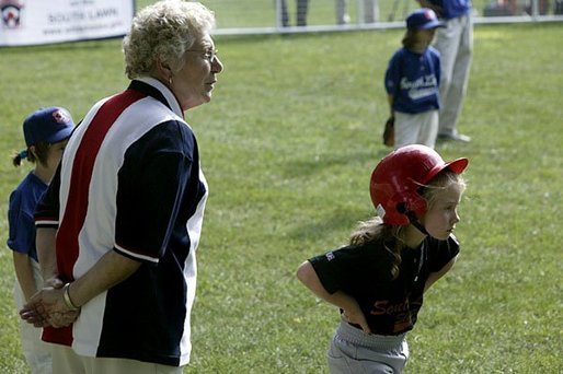 A runner with the Hamilton Little Lads of Hamilton, N.J., waits to make her next move with her honorary base coach Dolly White, former fielder with the Fort Wayne Daises and the Kenosha Comets, during the last game of the 2003 White House South Lawn Tee Ball season Sunday, Sept. 7, 2003. Ms. White played professional baseball with the All-American Girls Professional Baseball League Players Association, which operated from 1943 to 1954. White House photo by Lynden Steele.