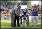 President George W. Bush and Honorary Commissioner Cal Ripken present a little leaguer with a warm congratulations and an autographed baseball after playing the last game of the 2003 White House South Lawn Tee Ball season Sunday, Sept. 7, 2003. White House photo by Lynden Steele.