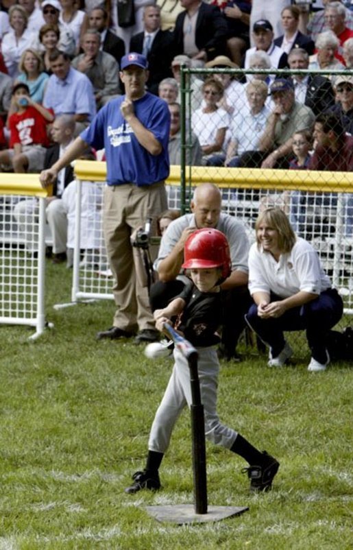 A little slugger from Kalamazoo, Mich., takes his hit under the expert gaze of Honorary Commissioner and Baltimore Orioles great Cal Ripken and Olympic Gold Medalist and Honorary Third Base Coach Dot Richardson during the last game of the White House South Lawn Tee Ball season Sunday, Sept. 7, 2003. White House photo by Lynden Steele.