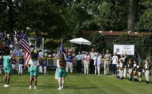 President George W. Bush stands for the singing of the national anthem with representatives of the All-American Girls Professional Baseball League Players Association during the opening ceremony for the last game of the 2003 White House South Lawn Tee Ball season Sunday, Sept. 7, 2003. The AAGPBL gave more than 600 woman the opportunity to play professional baseball from 1943 to 1954. White House photo by Lynden Steele.