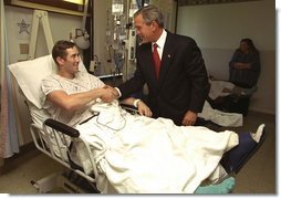 President George W. Bush shakes hands with Staff Sgt. Ethan Craig of Chester, Mass., after awarding him The Purple Heart at Walter Reed Army Medical Center Thursday, Sept. 11, 2003. Visiting with patients who were injured while serving in Operation Iraqi Freedom, President Bush awarded 11 Purple Hearts.  White House photo by Paul Morse