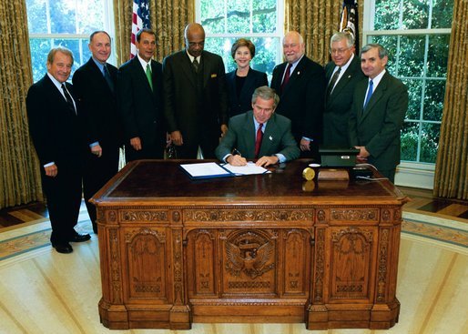 President George W. Bush signs into law, H.R. 13, the Museum and Library Services Act of 2003, in the Oval Office Thursday, Sept. 25, 2003. Pictured with the President are, from left: Congressman Ralph Regula, R-Ohio; Congressman Peter Hoekstra, R-Mich., Congressman John Boehner, R-Ohio., Education Secretary Rod Paige, Laura Bush, Dr. Robert Martin, Director of the Institute of Museum and Library Services; Senator Mike Enzi, R-Nev.; and Senator Jack Reed, D-R.I. White House photo by Tina Hager